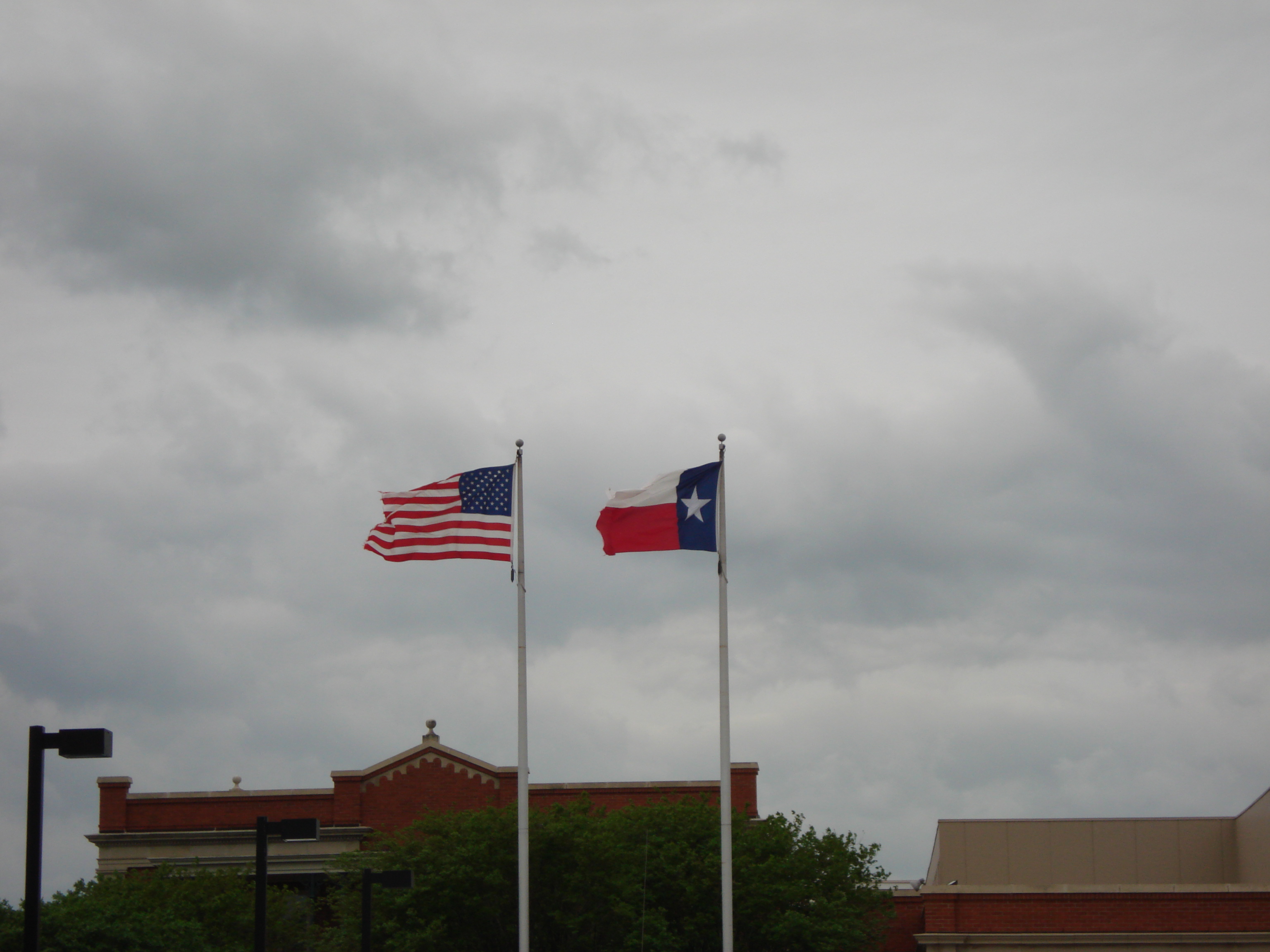 United States Flag and Texas flag flying on two flag poles