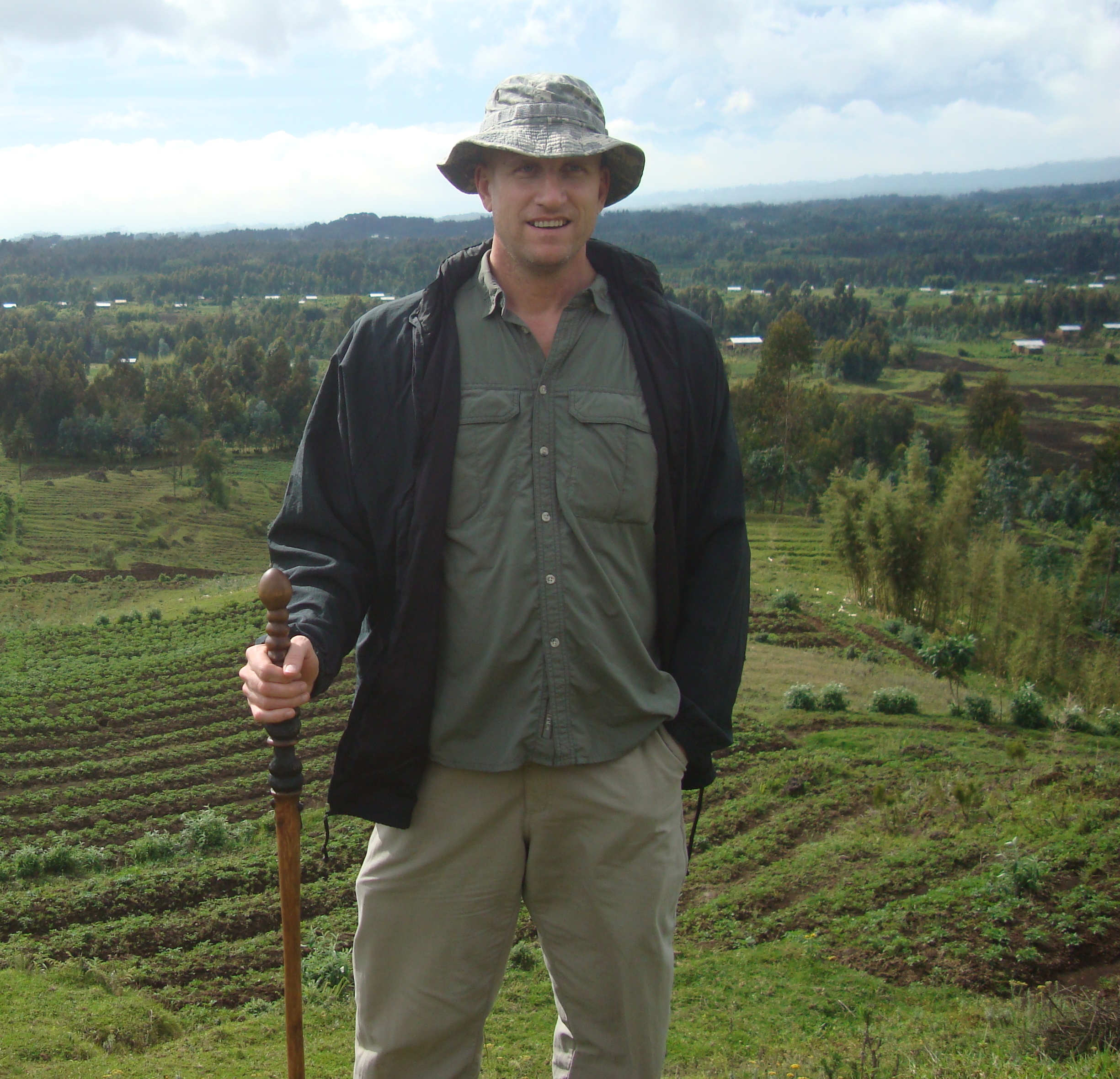 man on hill in rwanda uganda parc de volcanes gorilla trekking