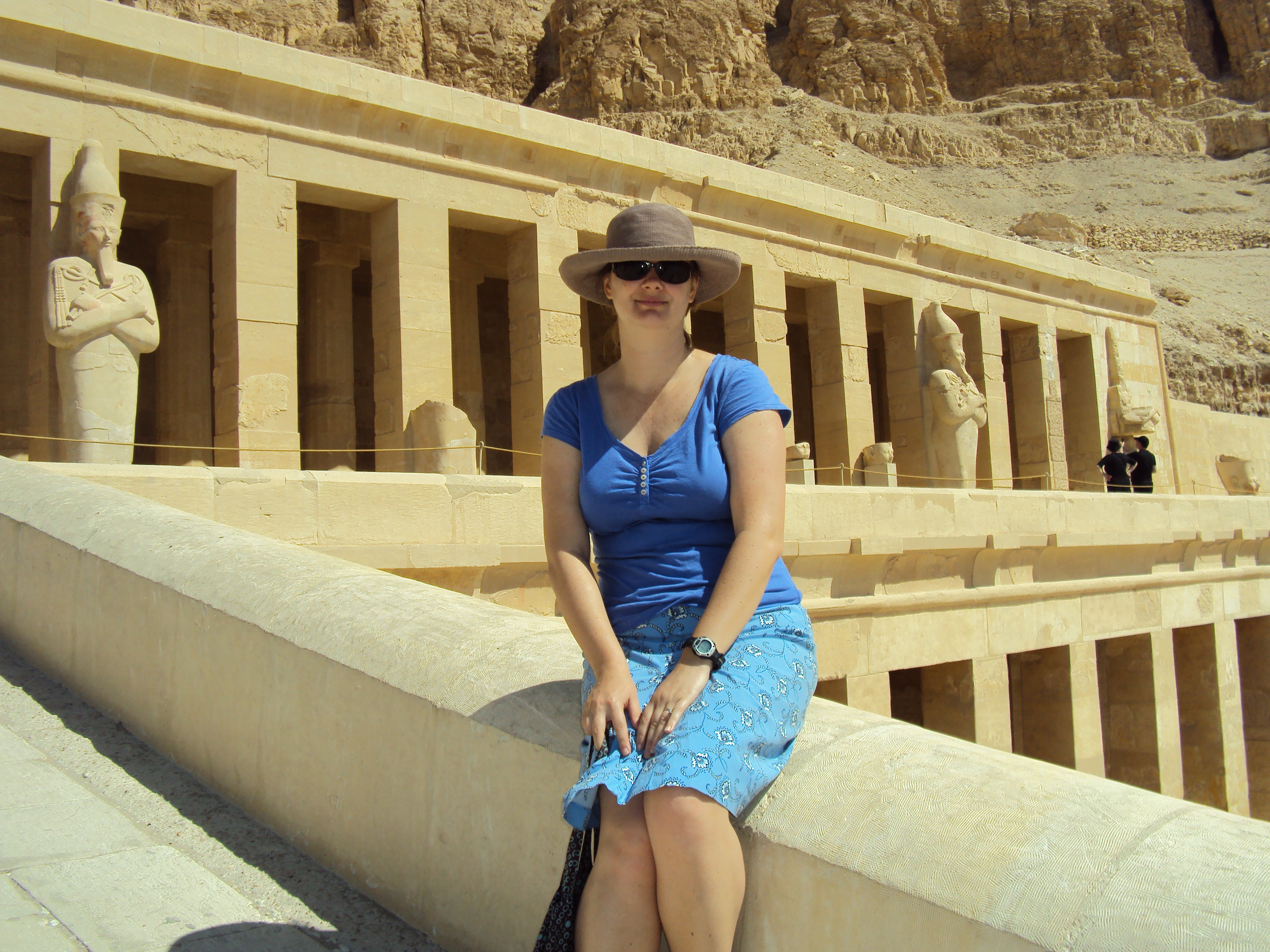 girl sitting in front of queen hetshepsut's temple in luxor egypt