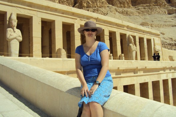 girl sitting in front of queen hetshepsut's temple in luxor egypt