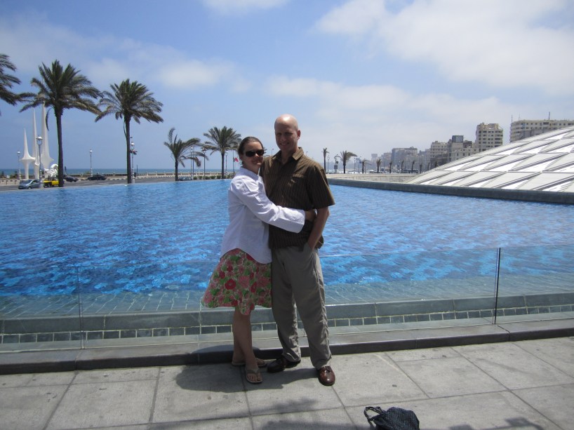 couple in front of water at library of alexandria egypt