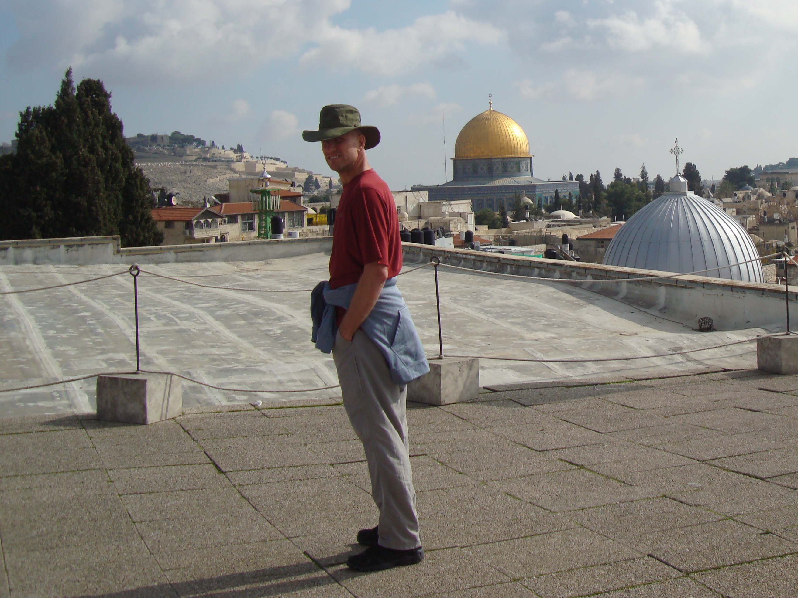man standing on roof in israel overlooking gold dome
