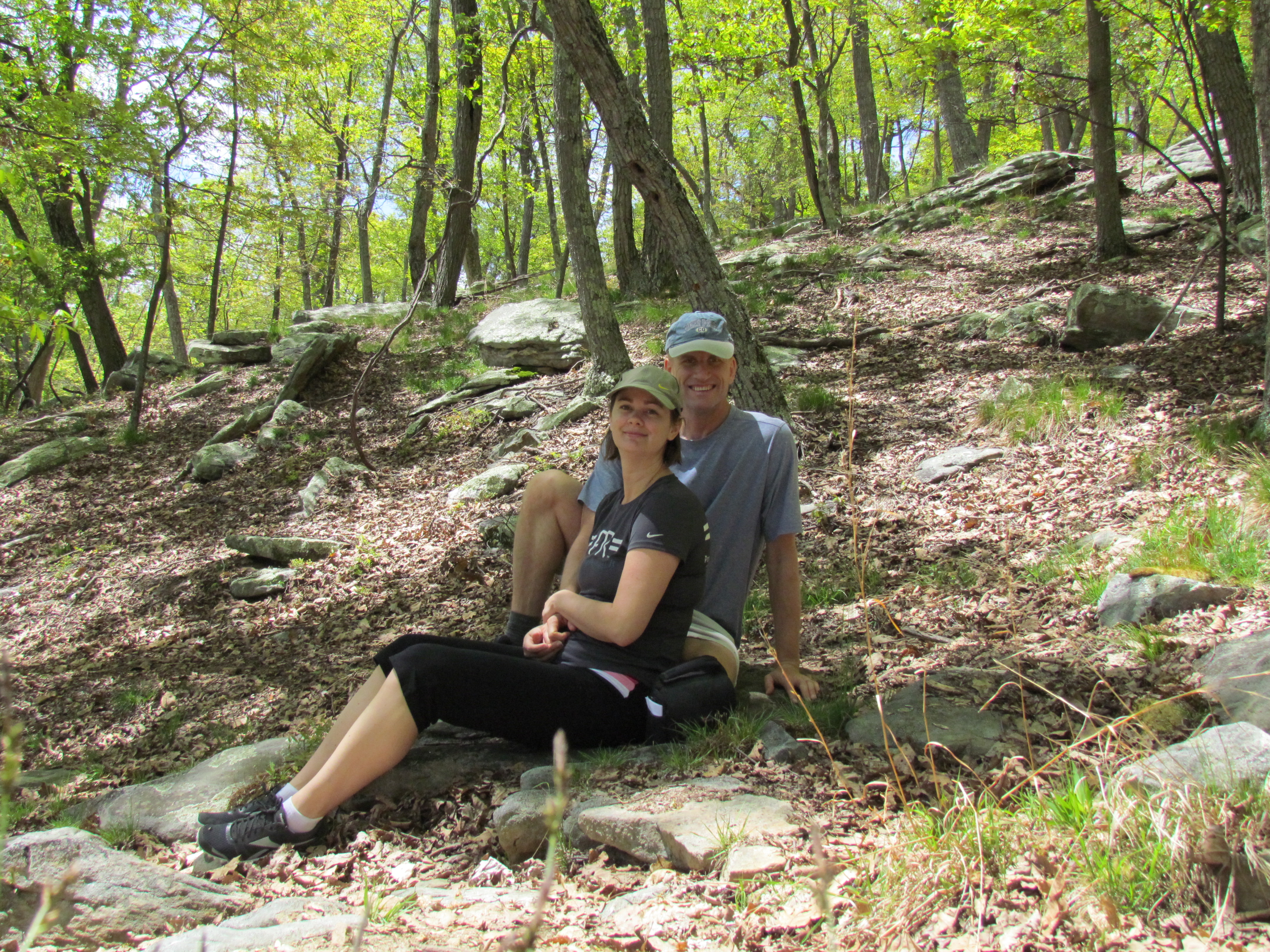 couple sitting on ground in forest berkeley springs west virginia