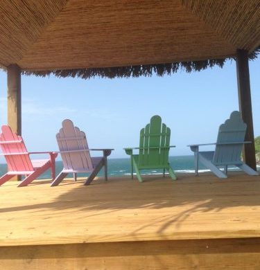 four colorful deck chairs overlooking ocean