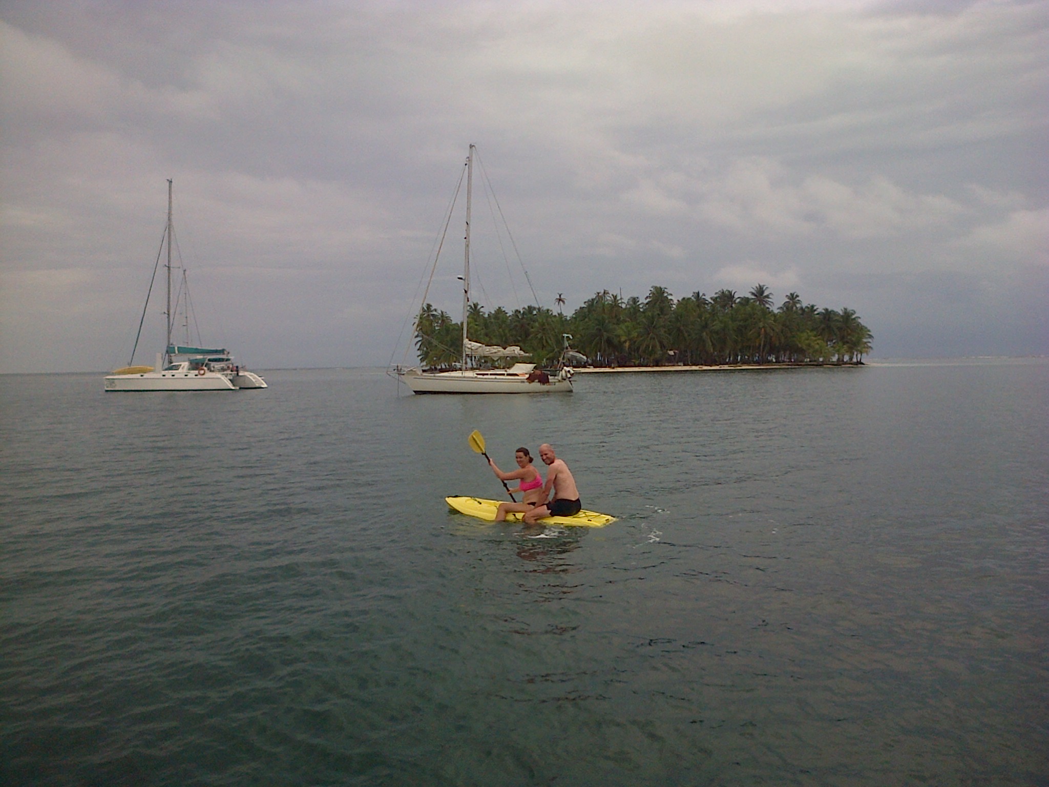 couple paddle board san blas islands sailboats panama