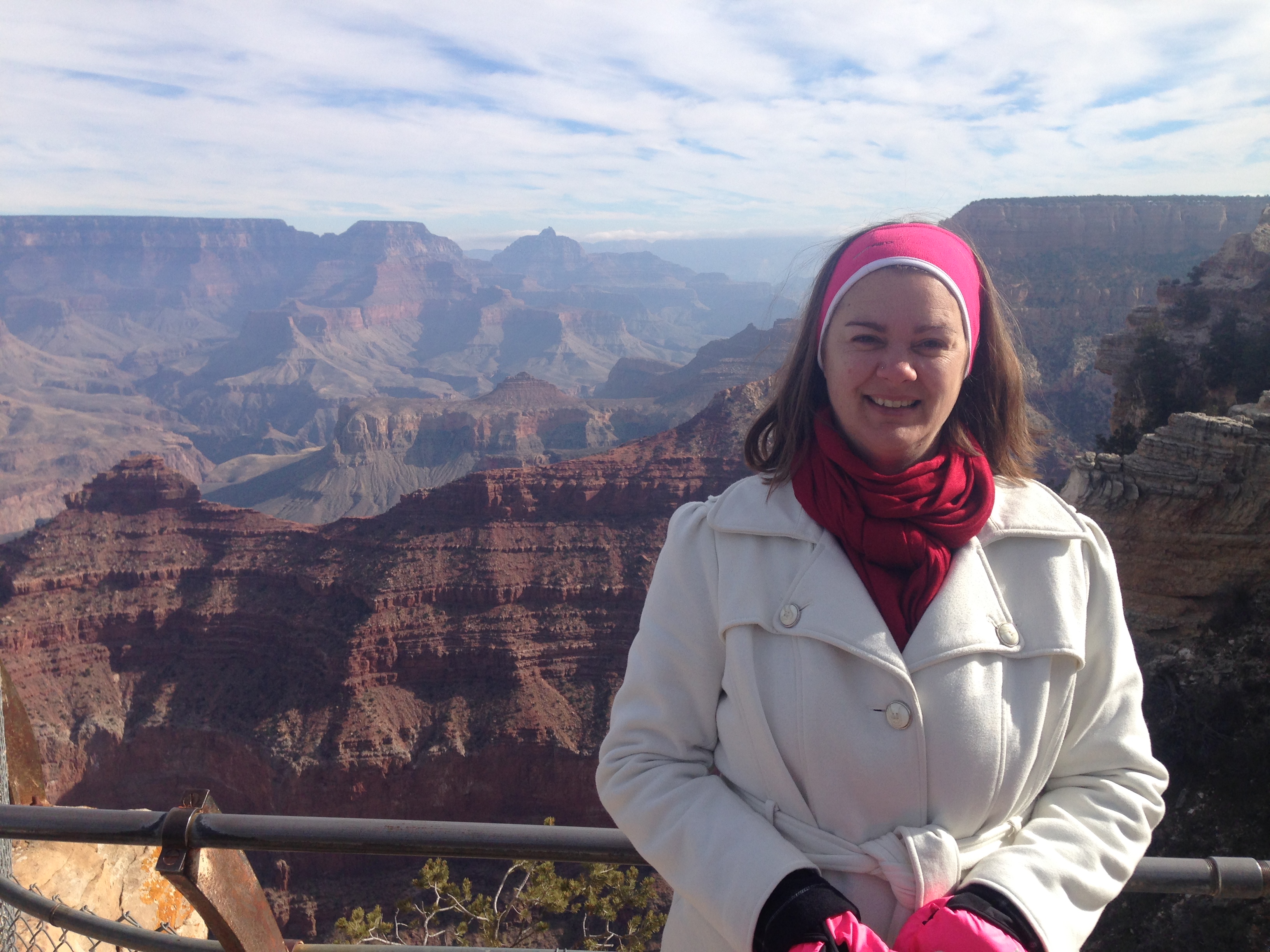 woman in white coat in front of grand canyon