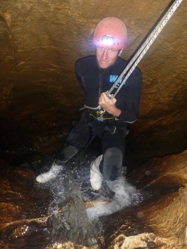 man spelunking into New Zealand glowworm cave