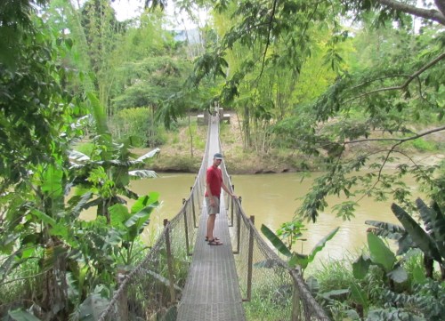 Chris on rope bridge over river in Papua New Guinea