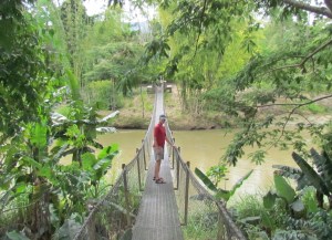 Chris on rope bridge over river in Papua New Guinea