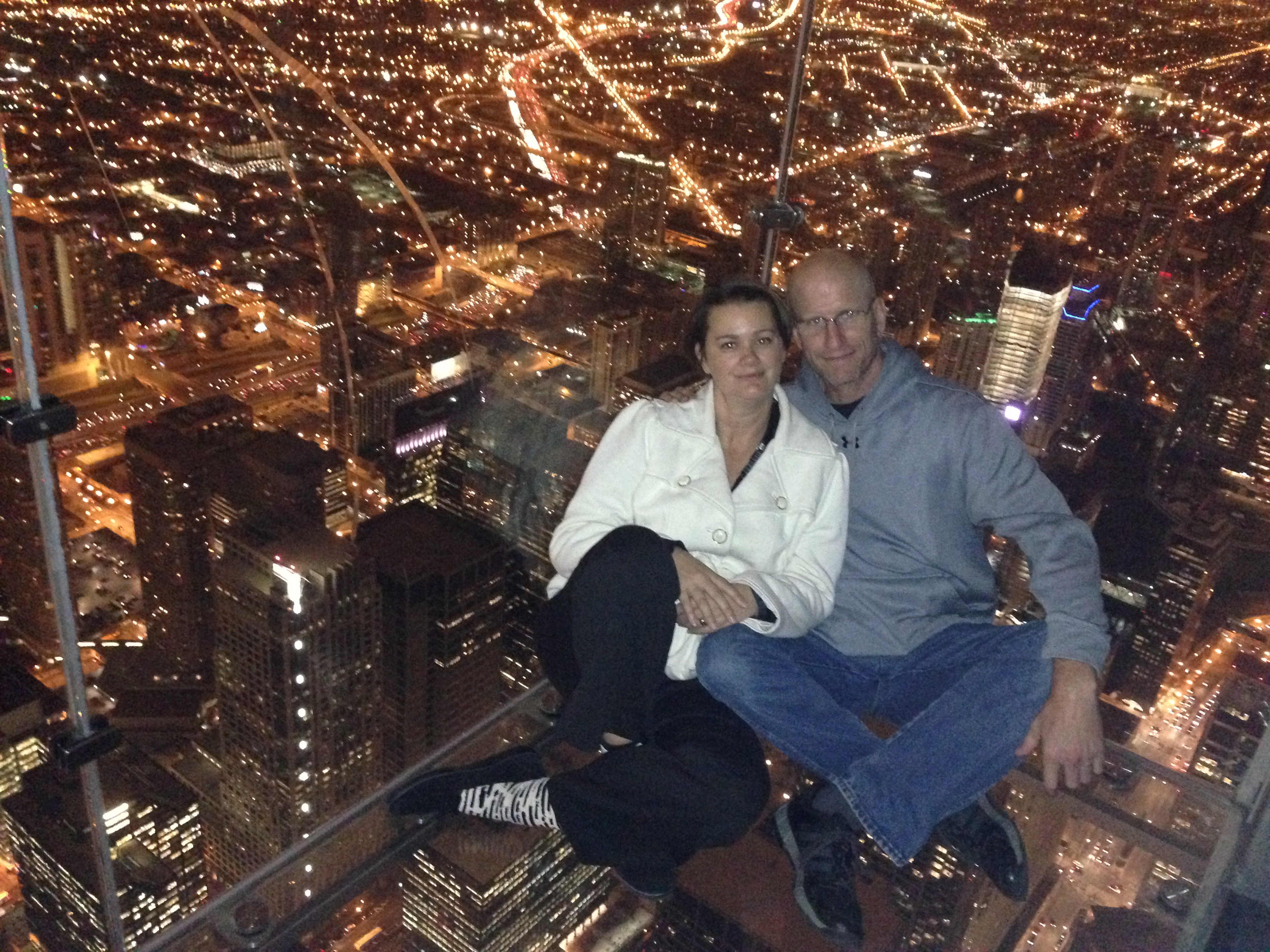 Couple sitting on glass floor Skydeck Chicago Willis Tower