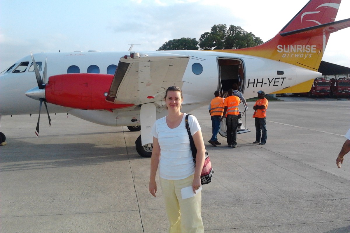 Deah in front of small plane in Haiti