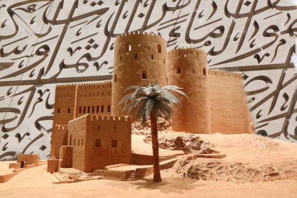 oman fortress model with arabic calligraphy in background